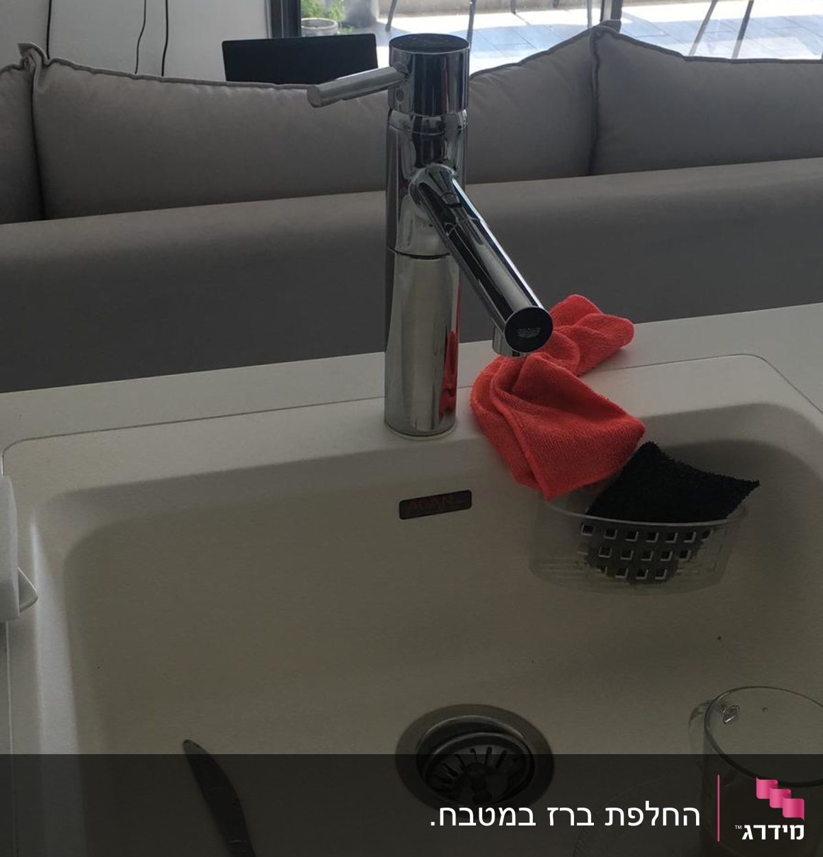 ברז נירוסטה בכיור עם ספוג ומטלית